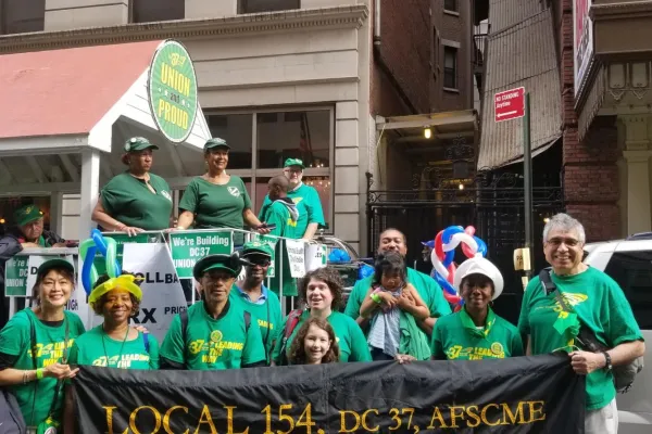 photo of Local 154 members with sign wearing green
