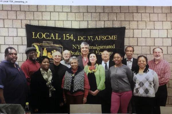 Member of Local 154 Executive board in front of Local 154 sign