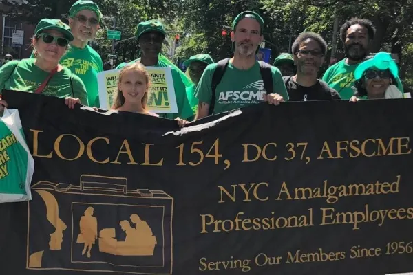 photo of Local 154 members with sign wearing green