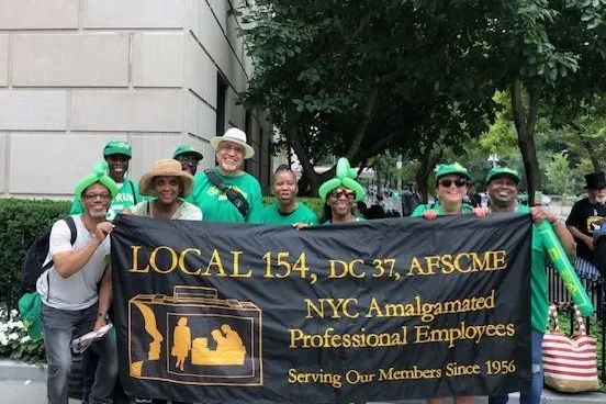 photo of Local 154 members with sign wearing green