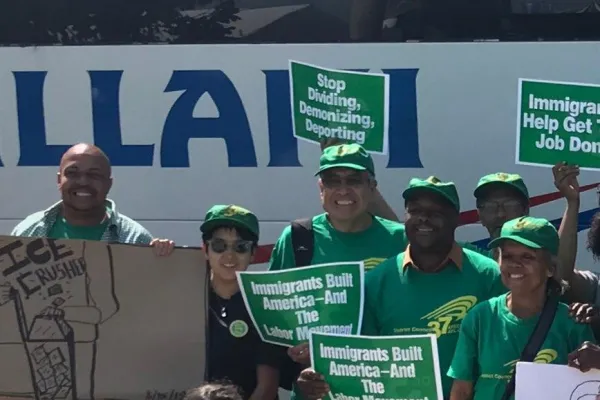 photo of Local 154 members with sign wearing green