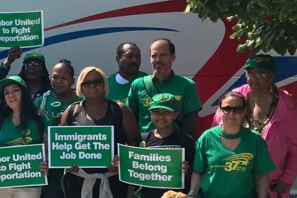 photo of Local 154 members with sign wearing green
