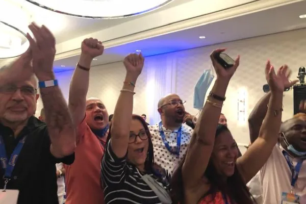 Member of Local 154 with fists raised during a conference meeting